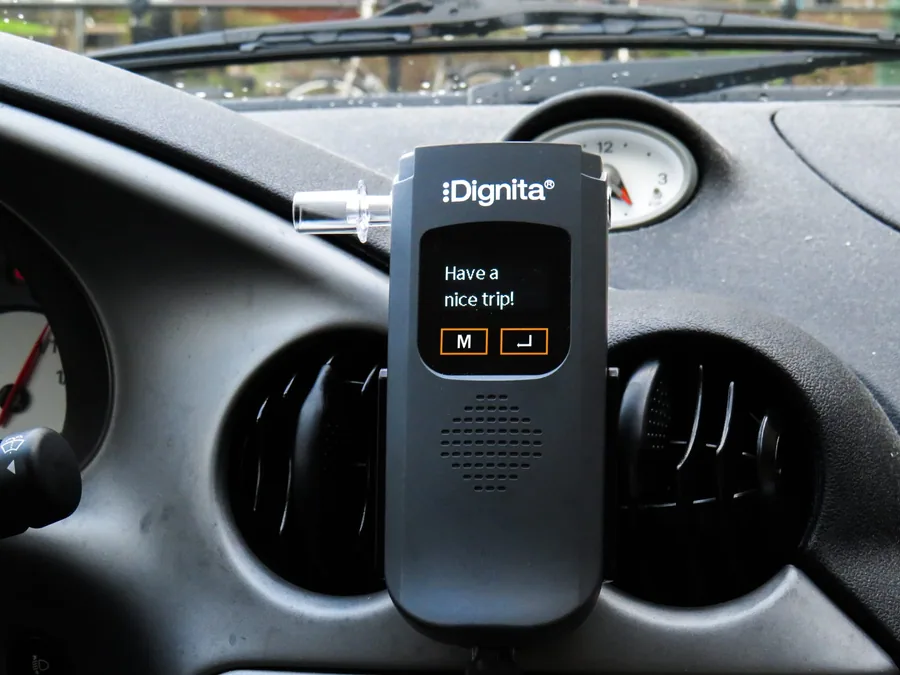 Dignita-alcoholslot in een houder op een dashboard bij Alcoholslot Auto