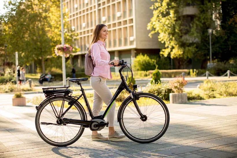 Vrouw die naast een fiets loopt op een officieel beeld van FietsZeker