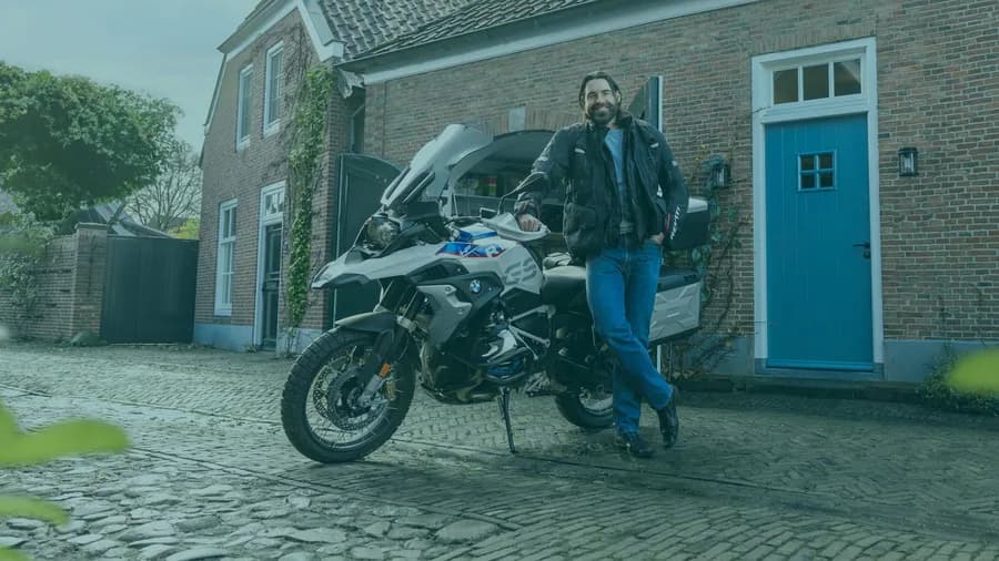 Motorrijder naast een motor op een officiële foto van Ikwilvanmijnmotoraf.nl