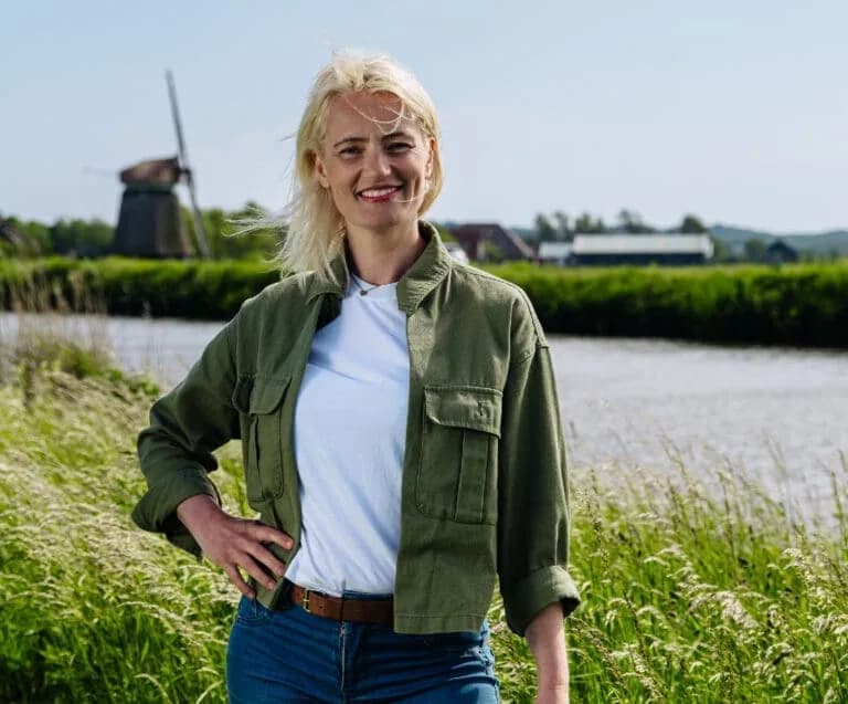 Vrouw bij water en een windmolen op een officieel beeld van om nieuwe energie